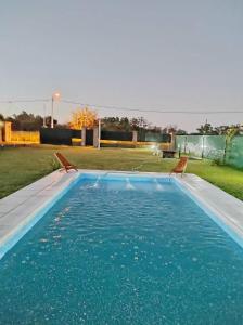 - une piscine avec 2 chaises dans l'eau dans l'établissement Cabaña La Nena, à Santa Rosa