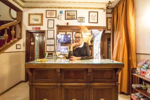 Una donna seduta al bancone in cucina di Hotel Lorena a Firenze