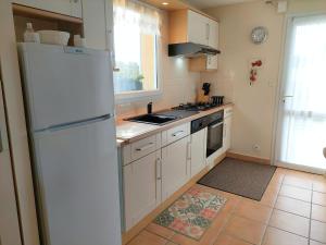 a kitchen with white cabinets and a white refrigerator at Cottage in Plouneour-Trez with Sea View in Plounéour-Trez