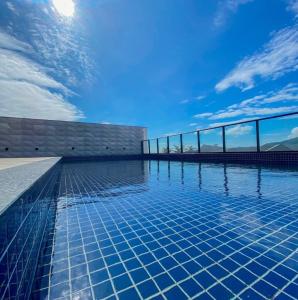 a swimming pool with a blue sky in the background at Apto Studio Square 990 - Vista Mar in Navegantes