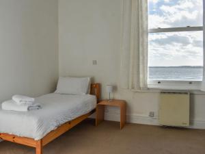 een slaapkamer met een bed en een raam met uitzicht op de oceaan bij Harbour View in Hartlepool