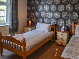 a bedroom with a bed and a wall with a wallpaper at Hollands Pond in Thorpe Saint Peter