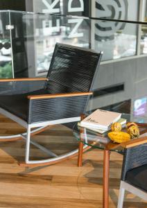 een zwarte stoel en een glazen tafel met een laptop erop bij Seekers Finders Rama IV Hotel SureStay Collection by BW in Bangkok