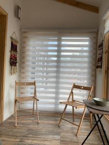 a room with two chairs and a window with blinds at Cabañas El jardín de Jacinta in Coihaique