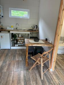 una pequeña cocina con una mesa de madera y una encimera en Cabañas El jardín de Jacinta en Coihaique