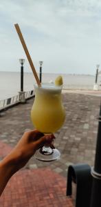 a person holding a drink with a stick in it at Ecusuites Super Host Penthouse 10 River View Puerto Santana in Guayaquil