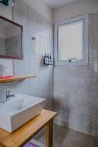 a bathroom with a white sink and a window at KUPAL in Esquel