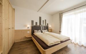 a bedroom with a large bed and a window at Waldheim Appartements in Bressanone