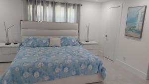a white bedroom with a bed with a blue comforter at CAPE CORAL CANALFRONT in Cape Coral +7 photos