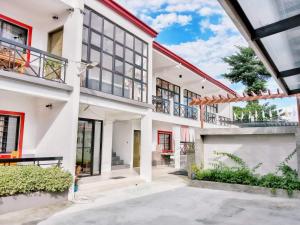 an exterior view of a white house with red accents at Maria Cristesa Condotel 