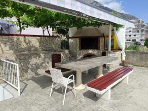 a picnic table and a bench and a stone fireplace at Apartment LEMONA in Makarska
