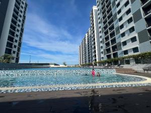uma piscina no meio de dois edifícios altos em Desaru Utama Residance Aisy Homestay em Kota Tinggi