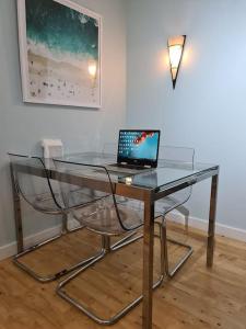 a glass table with a laptop on top of it at Impressive Apartment at Leeds City Centre in Leeds