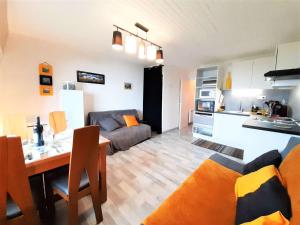 a kitchen and a living room with a couch and a table at Appartement Saint-Lary-Soulan, 2 pièces, 4 personnes - FR-1-457-308 in Saint-Lary-Soulan