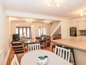 cocina y sala de estar con mesa y sillas en Quarry Cottage, en Cheddar