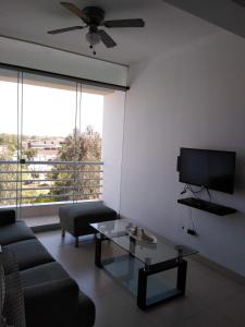 un soggiorno con divano e TV di Acogedor departamento WiFi a Piura