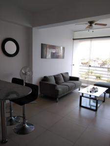 a living room with a couch and a table at Acogedor departamento WiFi in Piura