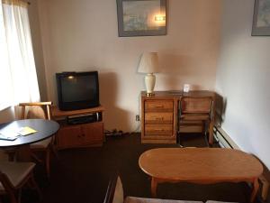 a living room with a tv and a table and a table sidx sidx at Chris by the Sea Motel in Ocean Shores