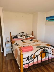 a bedroom with a bed with a comforter at Campbell Casa in Kingscote