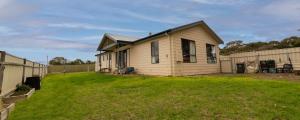 a small house in a yard next to a fence at Campbell Casa in Kingscote