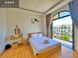 a bedroom with a bed and a large window at HANZ Teddy Sunset Grand World in Phu Quoc