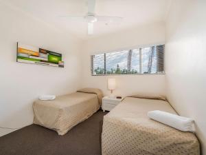 a bedroom with two beds and a window at 23 Sunseeker in Sunshine Beach