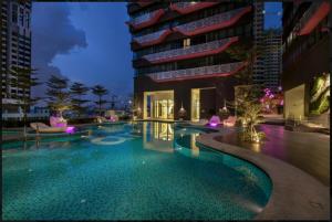 a swimming pool in front of a building at night at ARTE plus Jalan Ampang - KLCC in Kuala Lumpur