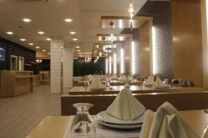a restaurant with tables with white napkins on them at Enar Hotel in Kırıkkale