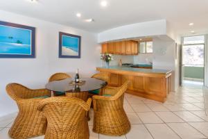 a kitchen with a table and chairs and a counter at Lagoon Beachfront Lodge 107 on Hamilton Island by HamoRent in Hamilton Island