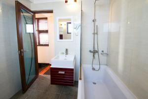 ein Badezimmer mit einer Badewanne, einem Waschbecken und einer Badewanne in der Unterkunft Tropic Tree Maldives in Gulhi