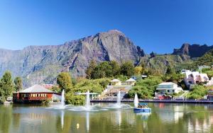 a small town on a lake in front of a mountain at CASAMELIAS "La glycine" in Cilaos