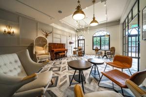 a living room with chairs and tables and a piano at Otis Inn in Hualien City