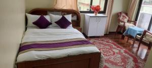 una camera da letto con un grande letto con cuscini viola di Kathmandu Airport View Hotel And Lodge a Kathmandu