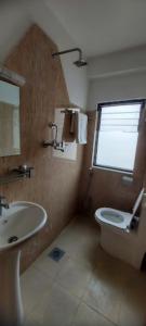 een badkamer met een wastafel, een toilet en een raam bij Kathmandu Airport View Hotel And Lodge in Kathmandu