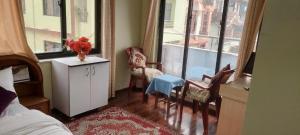 una camera da letto con un letto, un tavolo e delle sedie di Kathmandu Airport View Hotel And Lodge a Kathmandu