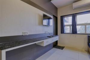 a kitchen with a counter with a sink and a window at Hotel Kumar Atithi Nivas in Indore