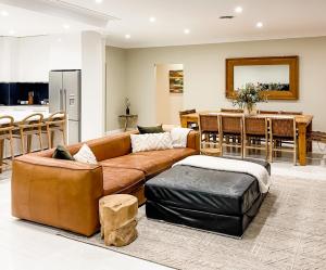 ein Wohnzimmer mit einem Sofa und einem Tisch in der Unterkunft Hamilton House - Snowy Mountain Luxury Villas in Jindabyne