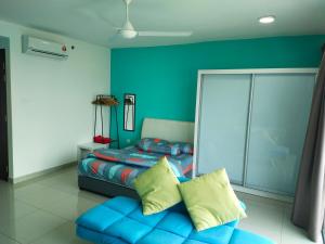 a bedroom with a bed and a blue wall at TREFOIL@SETIA CITY, STUDIO UNIT,HOMESTAY in Shah Alam