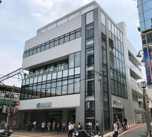 un groupe de personnes debout à l'extérieur d'un bâtiment dans l'établissement Spring Apartment Shinjuku, à Tokyo