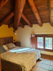 Aliaga的住宿－Hotel Molino Alto，一间带一张床的卧室,位于带木制天花板的房间内
