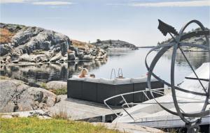 Una donna seduta in una vasca da bagno su un molo in acqua di Holiday Home Flekkerøy Paulen Iii a Møvik