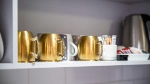 een plank met gouden koffiemokken erop bij Sunshine Retreat Villa 7 in Cowes
