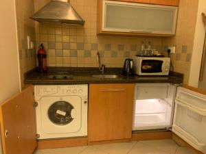 a kitchen with a washing machine and a microwave at Belle Vue Building in Dubai