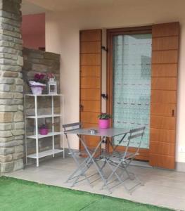 a table and chairs in front of a house at Casa Vacanza IL CICLAMINO in Borno