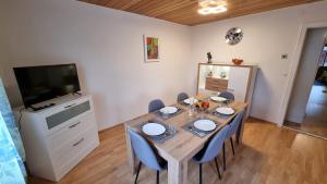 ein Esszimmer mit einem Tisch mit Stühlen und einem TV in der Unterkunft Germanus Ferienwohnung in Warmensteinach