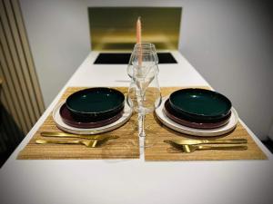 a table with two plates and a wine glass at L’ODYSSÉE SPA in Seclin