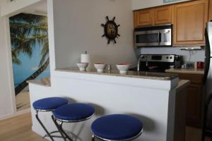 une cuisine avec quatre tabourets bleus sur un comptoir dans l'établissement Fun-N-Sun with Spectacular Ocean Views, à Tampa