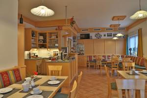 ドルフガシュタインにあるペンション ポザウナーのテーブルと椅子のあるレストラン、キッチンが備わります。