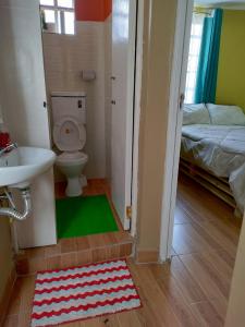 Un baño con inodoro, lavabo y cama. en Gardenia Haven, en Nairobi