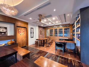 a dining room with wooden tables and chairs at 沐眠宿 Moment Inn - 快速入住 好停車 in Tainan
